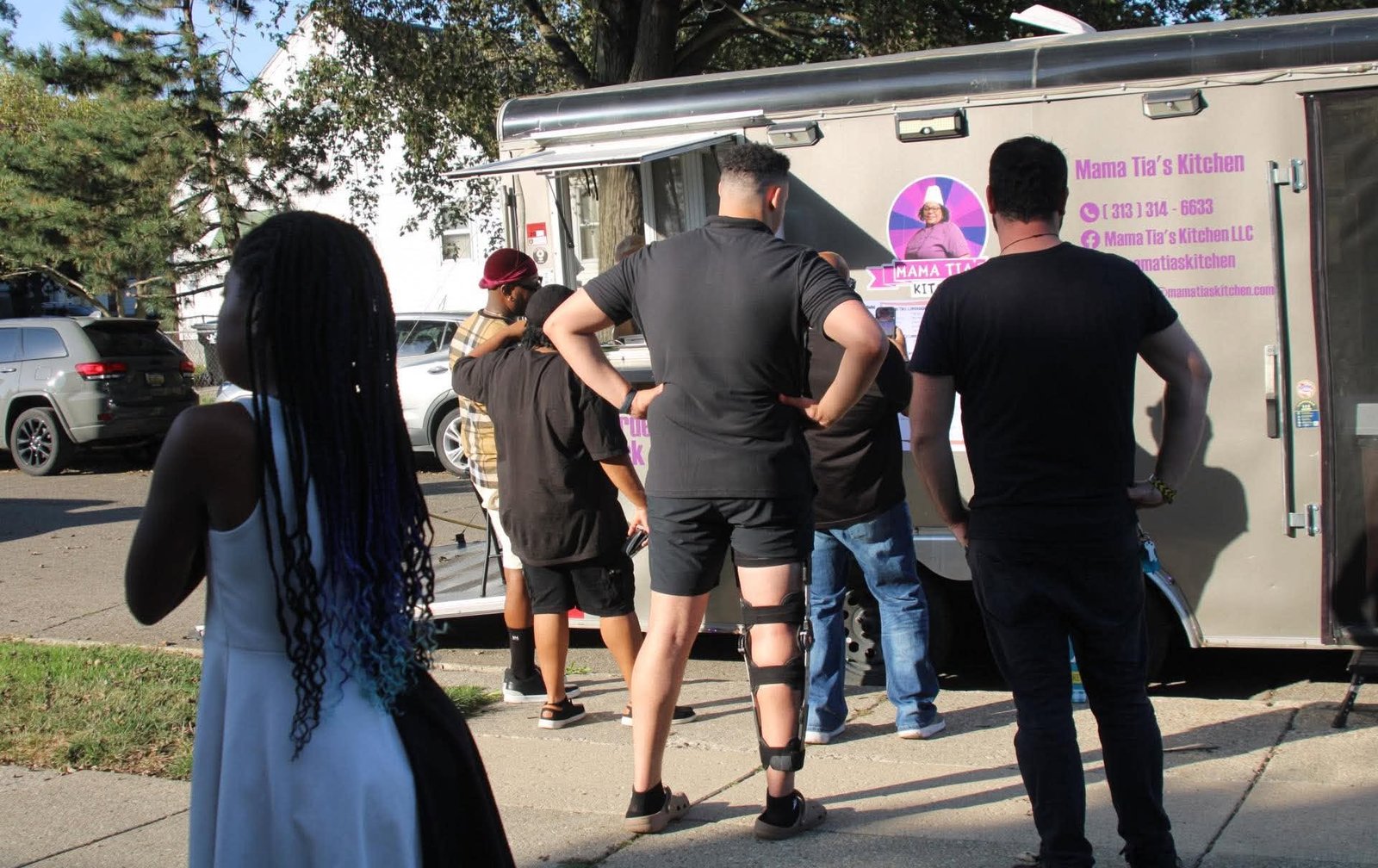 Guests lining up at the Mama Tia's Kitchen food trailer at a neighborhood event