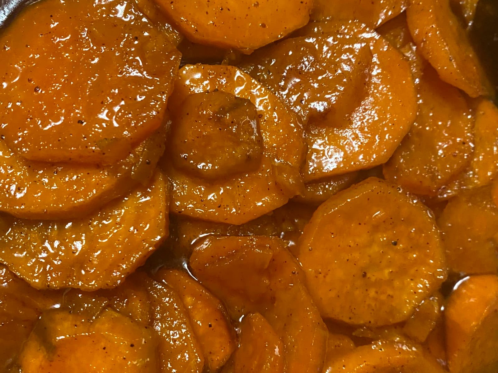 Candied yams simmering in a buttery brown sugar glaze